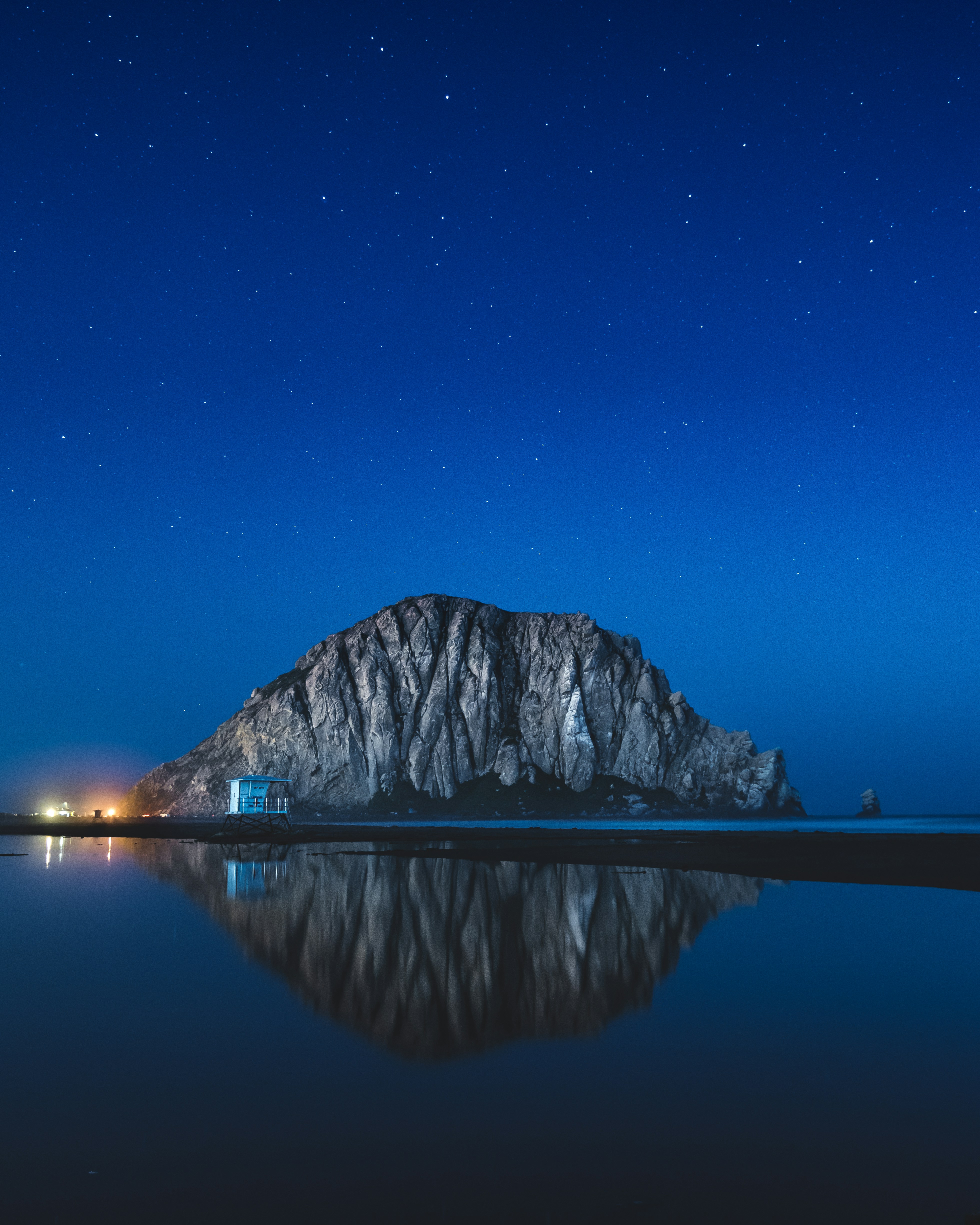 a large mountain sitting on top of a lake under a night sky