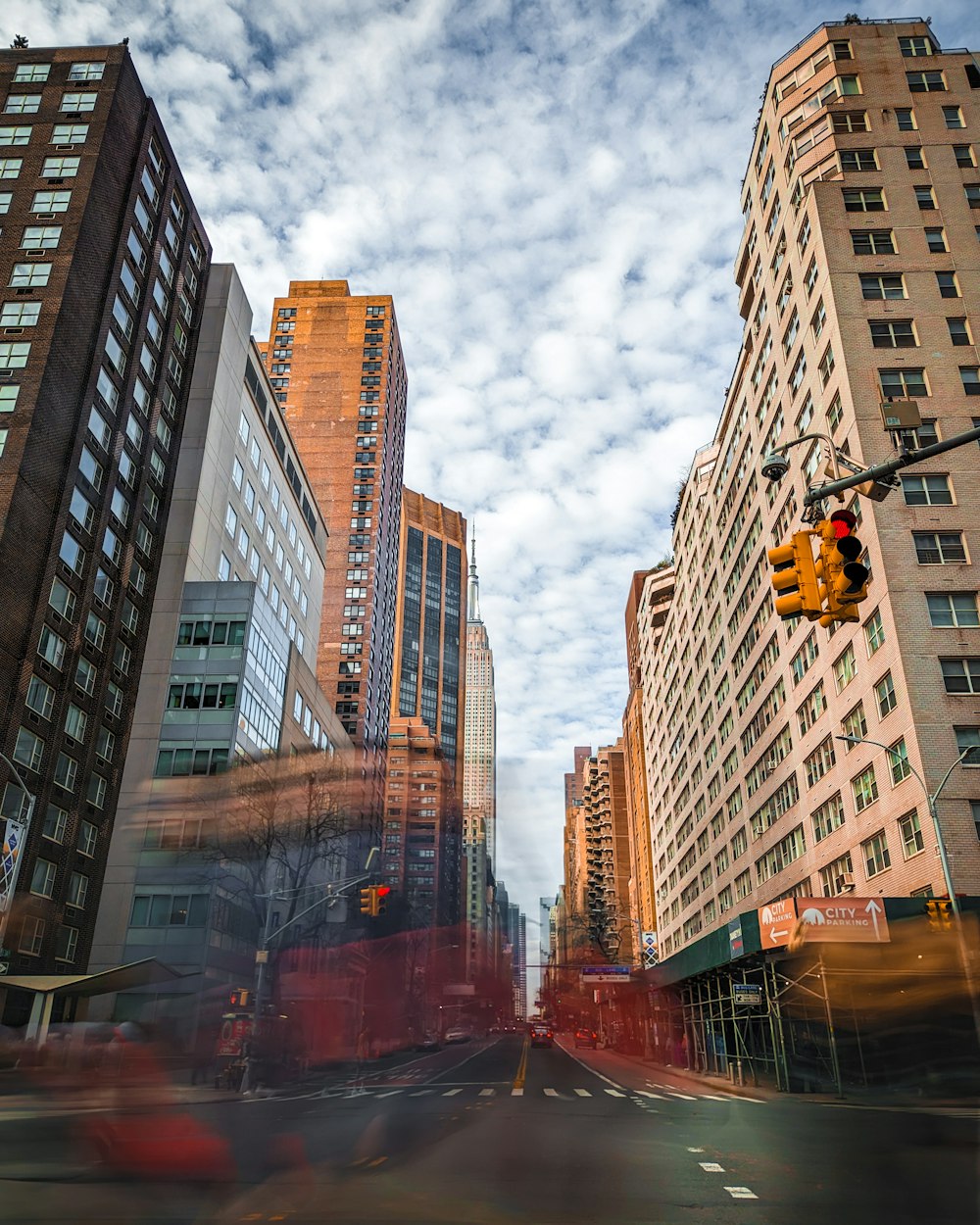 a traffic light hanging over a street next to tall buildings