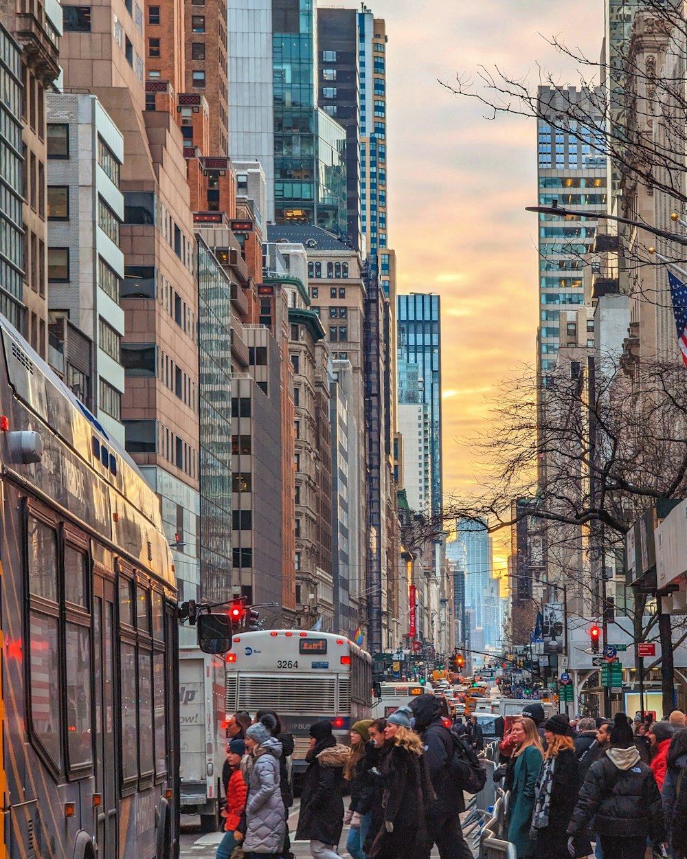 a group of people walking down a street next to tall buildings