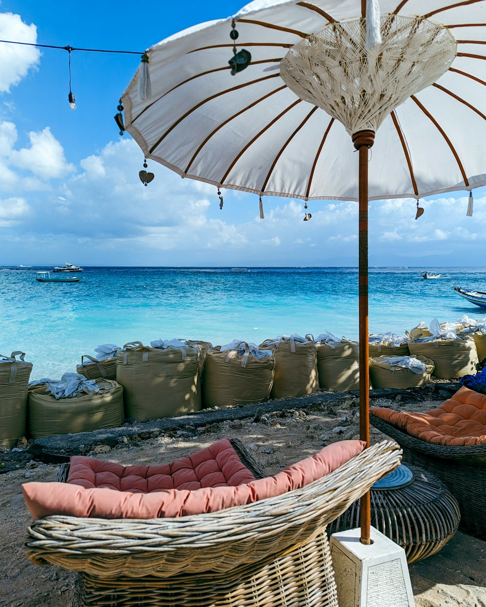 a white umbrella sitting on top of a sandy beach