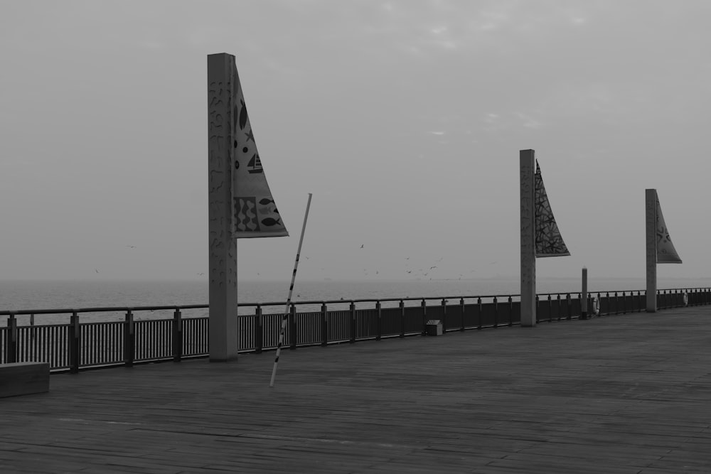 a black and white photo of flags on a pier