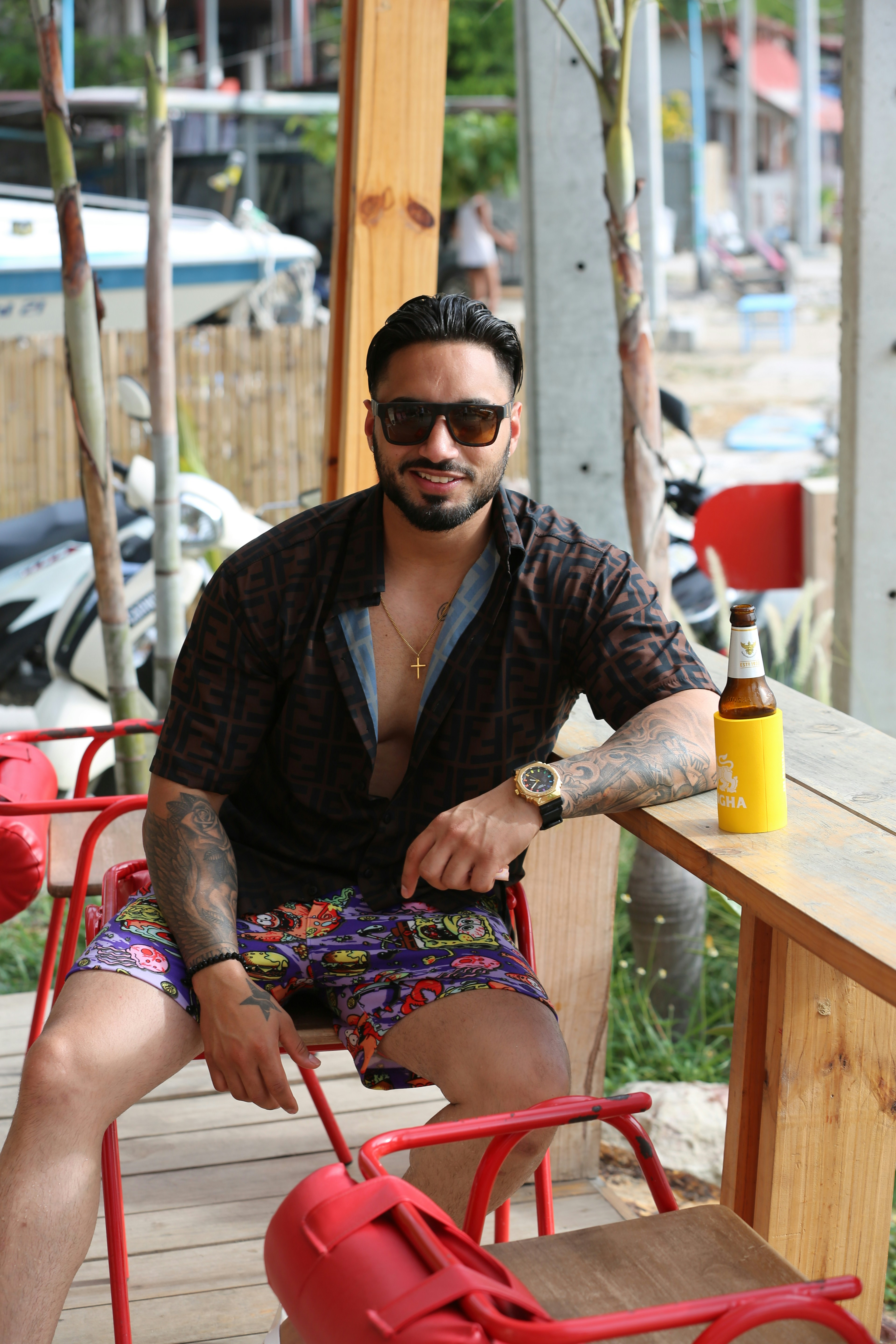 a man sitting at a table with a bottle of beer