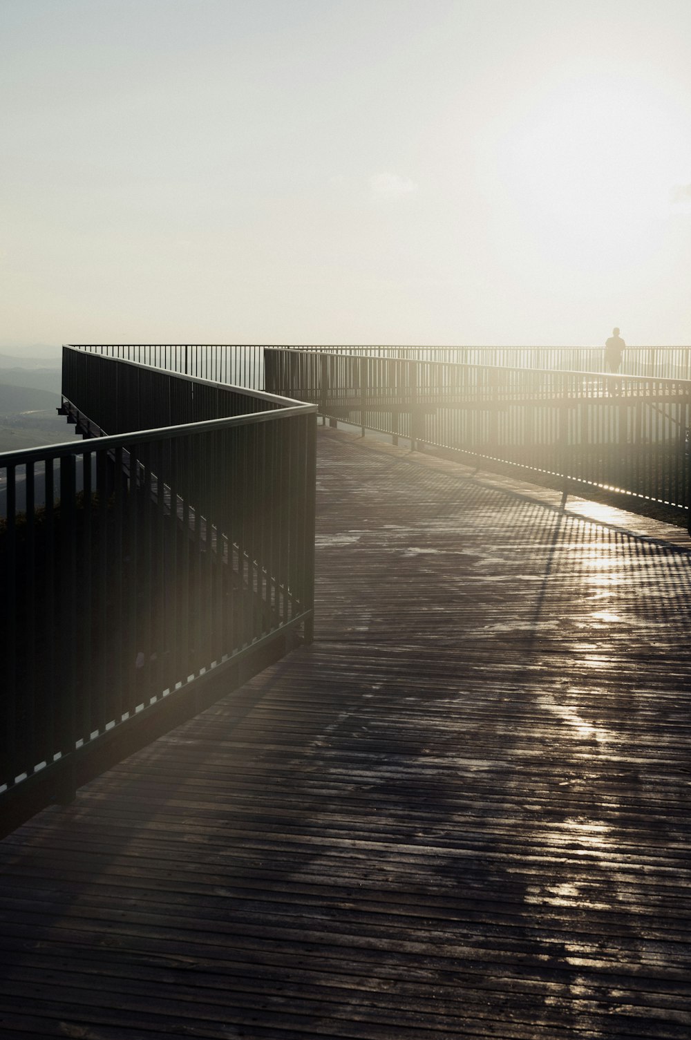 a wooden walkway leading to the ocean on a sunny day