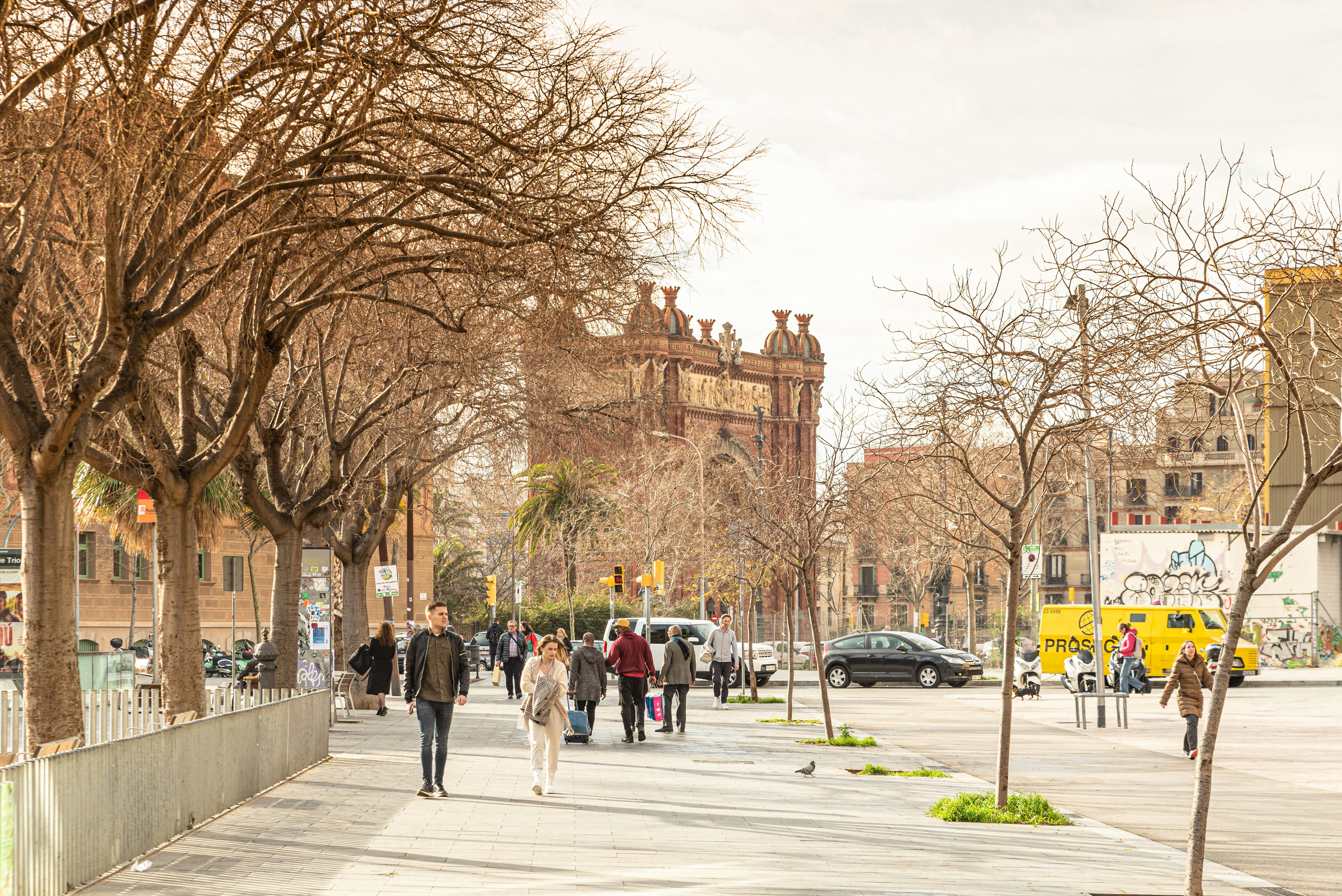 a group of people walking down a street next to tall buildings