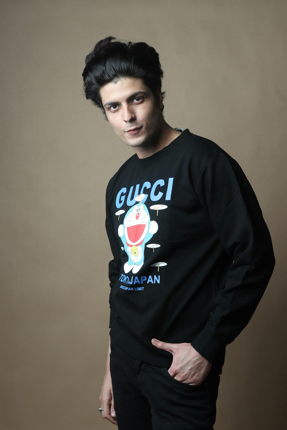 a man in a gucci sweatshirt poses for a picture