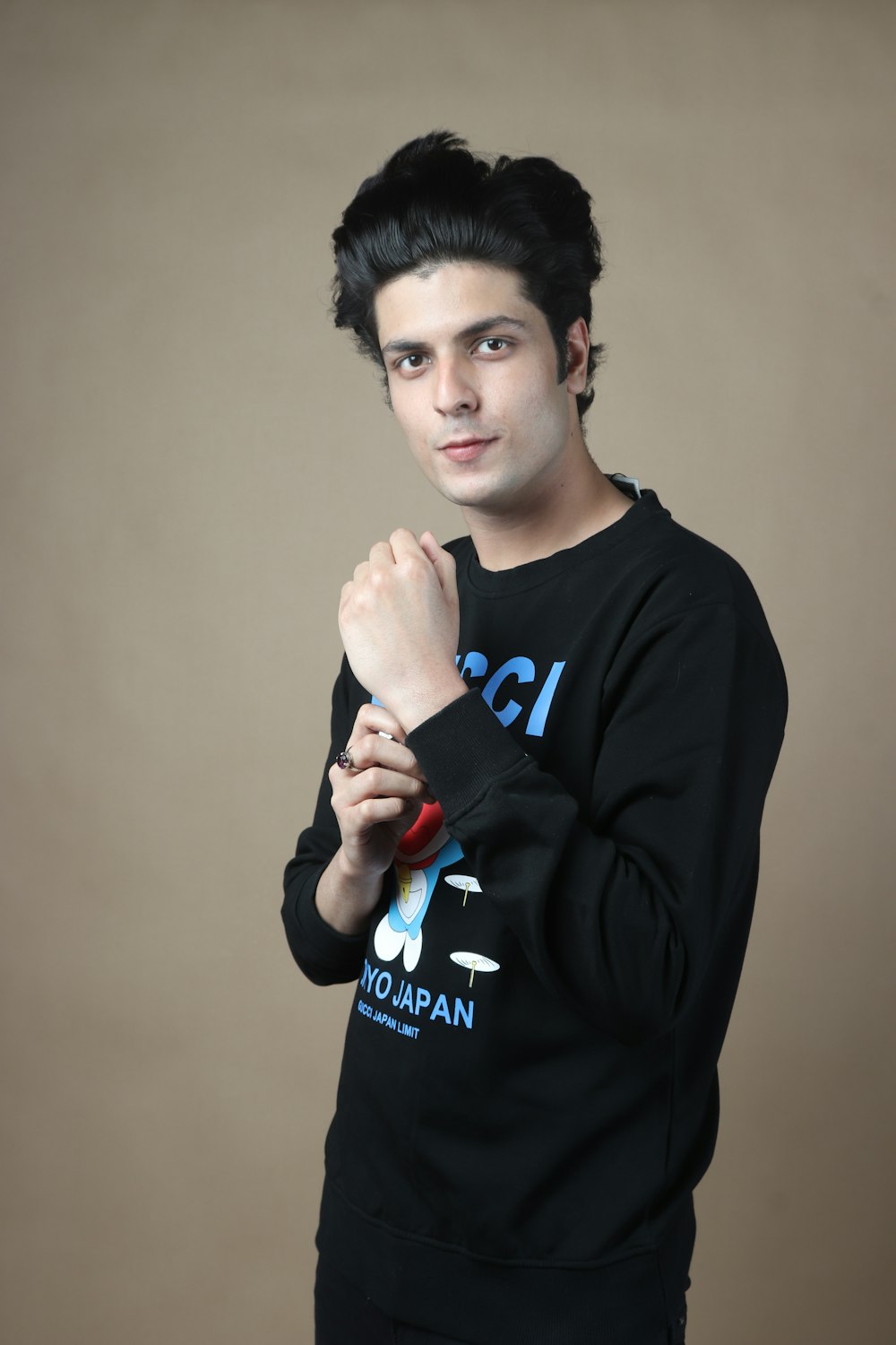 a young man posing for a picture in a black sweatshirt