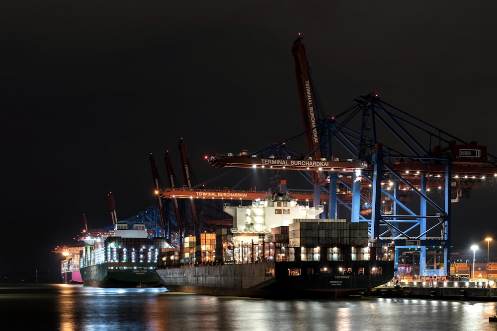 a large cargo ship in a harbor at night