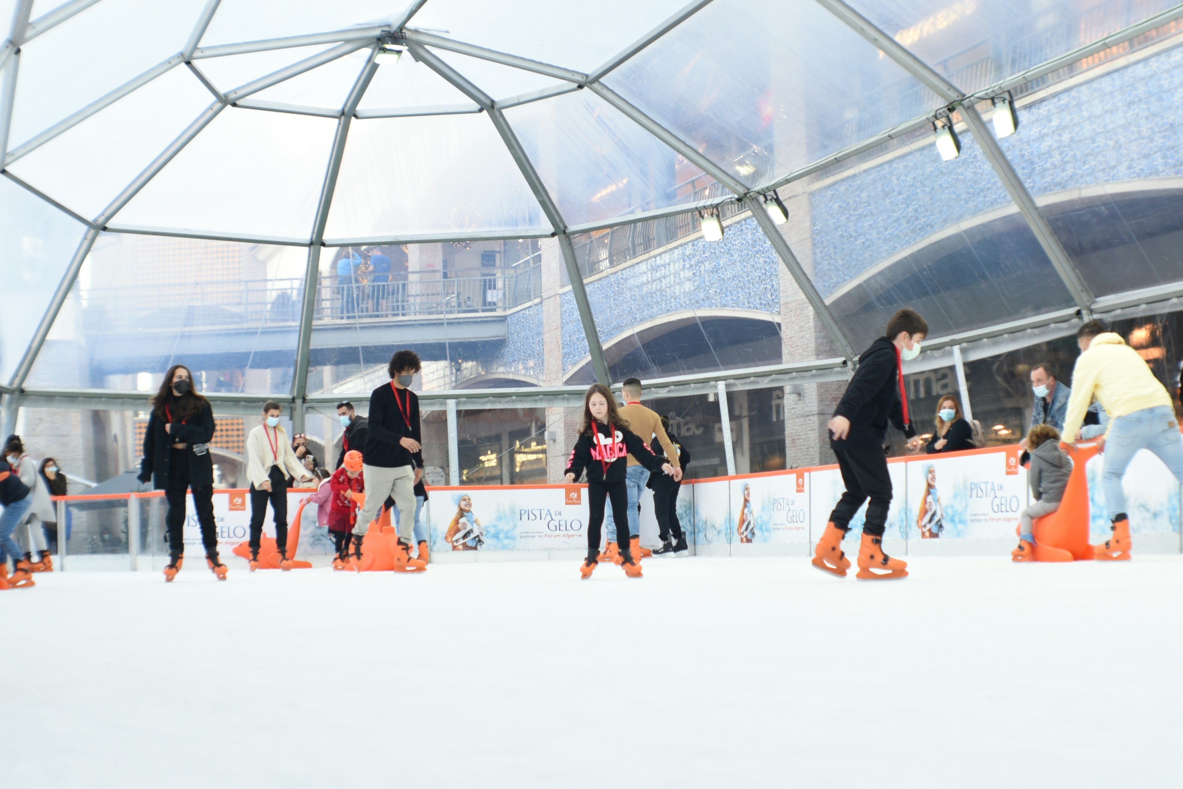 um grupo de pessoas patinando em uma pista de gelo