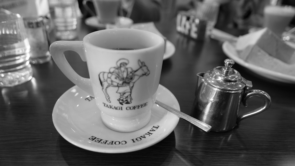 a black and white photo of a coffee cup and saucer