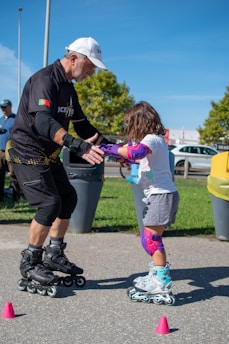 a man teaching a little girl how to skate