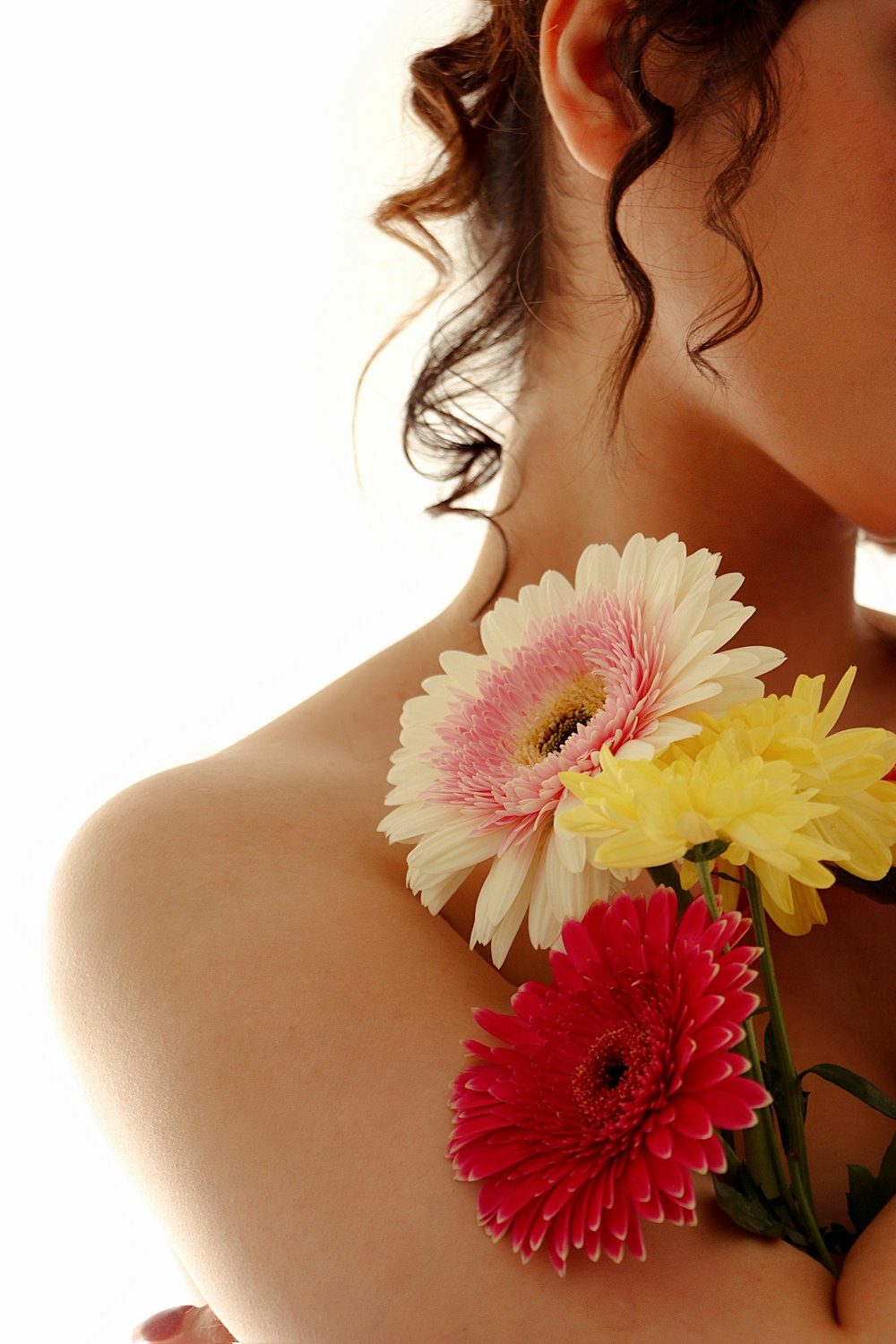 a woman holding a bunch of flowers in her chest