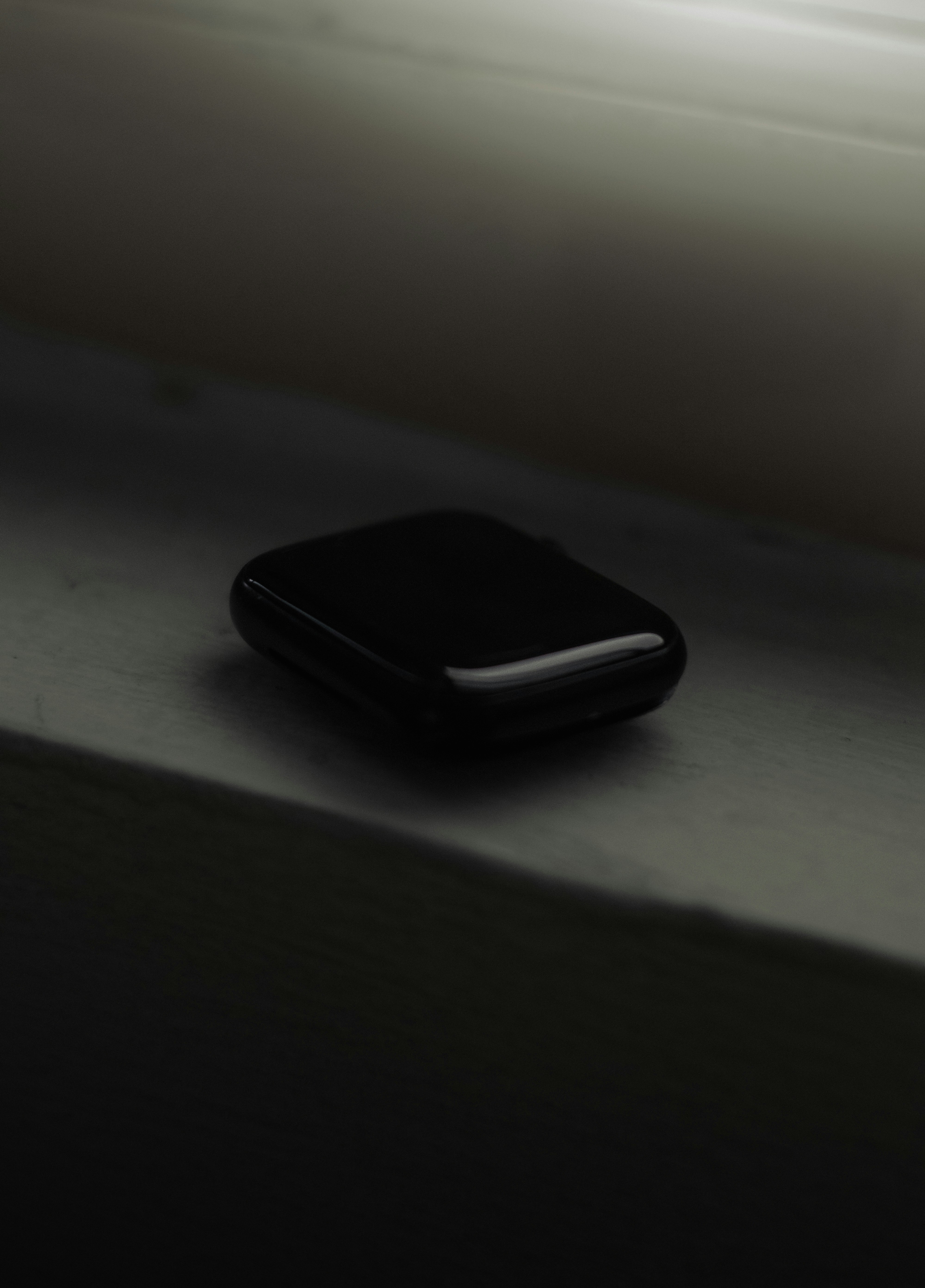 a black cell phone sitting on top of a window sill
