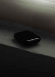 a black cell phone sitting on top of a window sill
