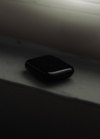 a black cell phone sitting on top of a window sill