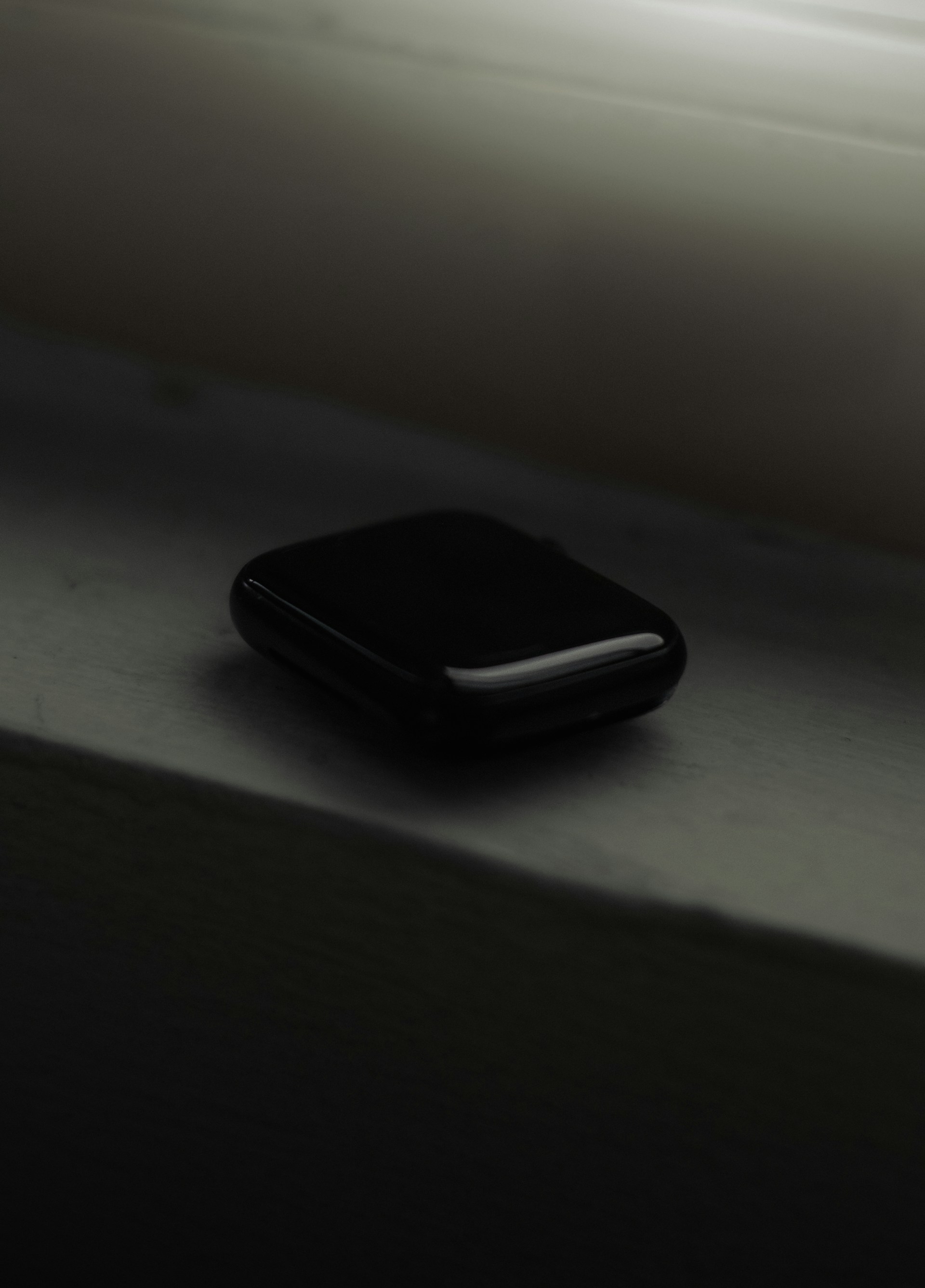 a black cell phone sitting on top of a window sill