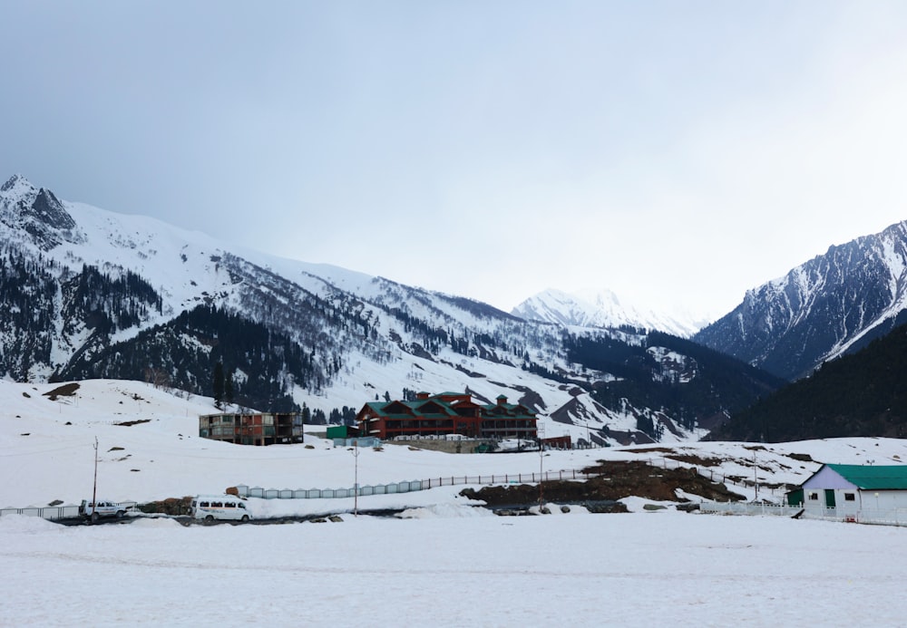 a snow covered mountain with houses and mountains in the background