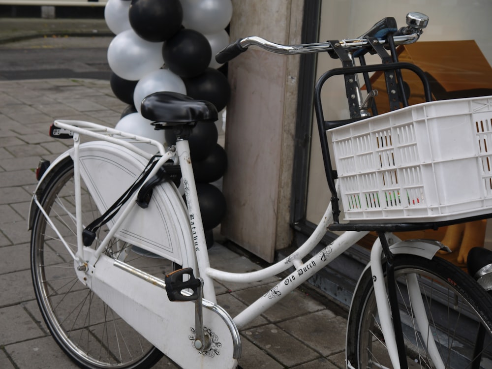 a white bicycle parked next to a building