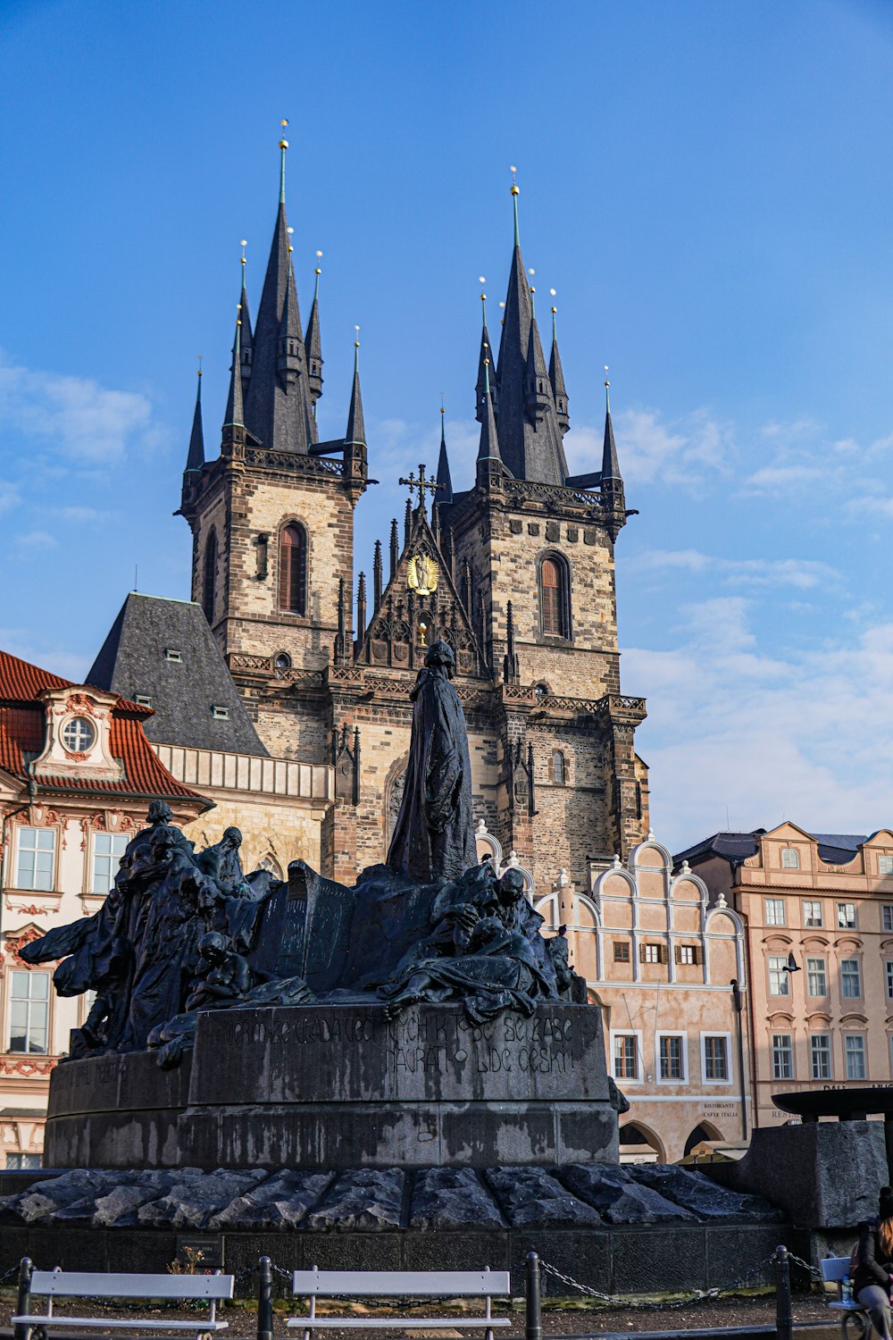 a statue in front of a castle with a clock on it