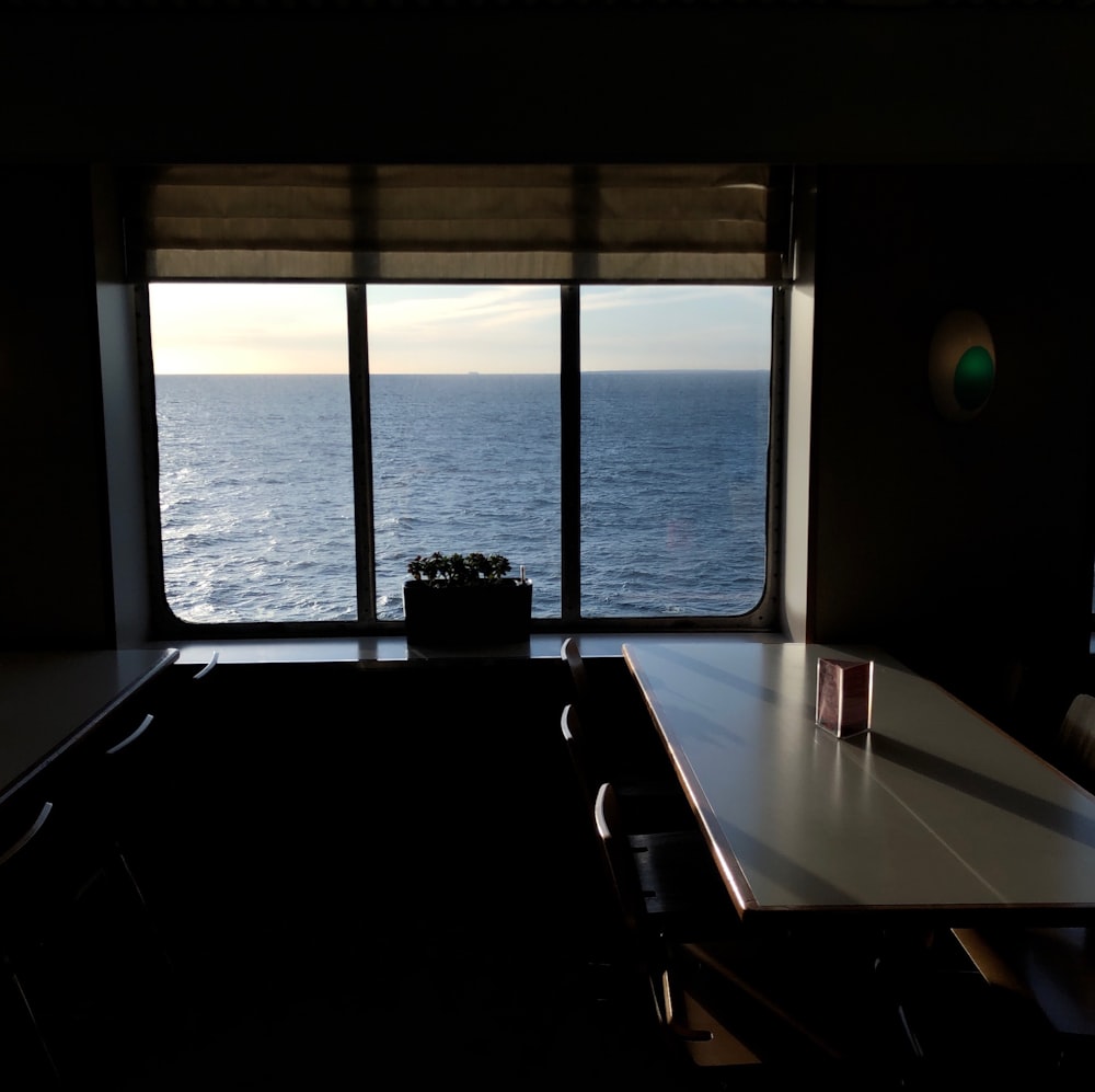 uma sala com mesa e vista para o oceano