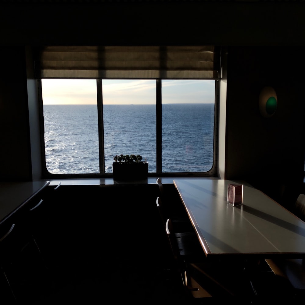 a room with a table and a view of the ocean