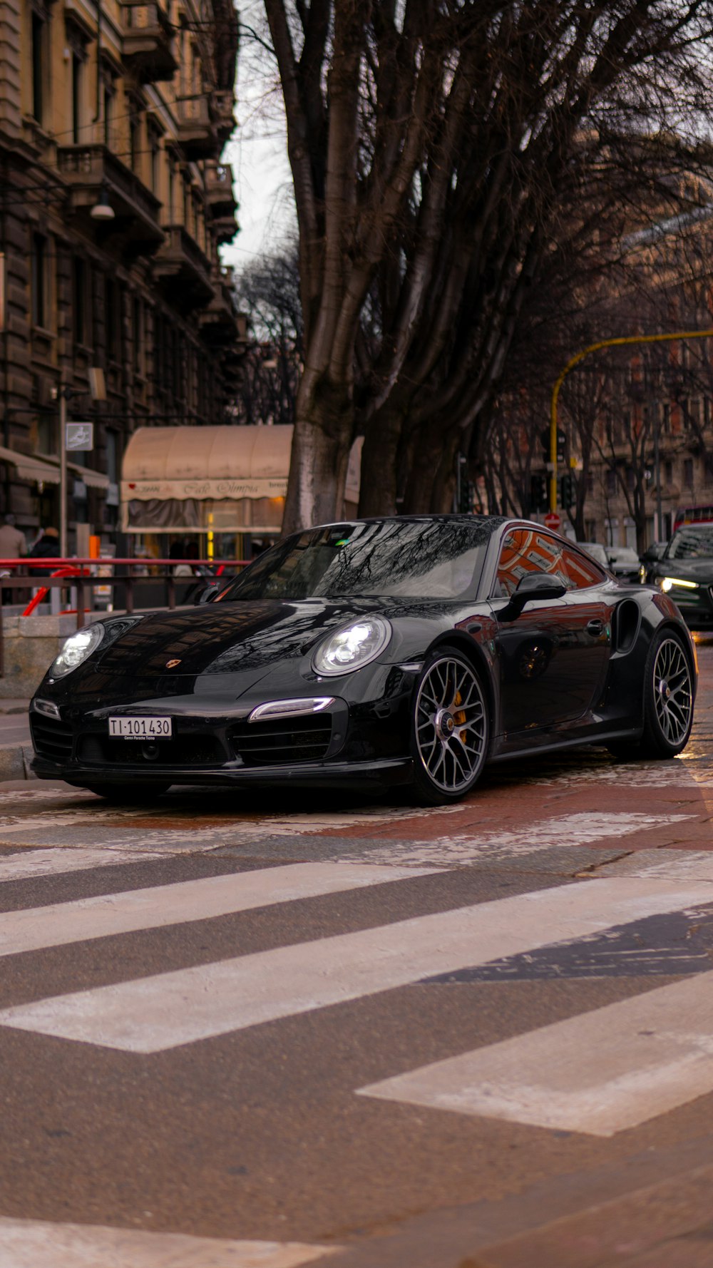 a black porsche parked on the side of the road