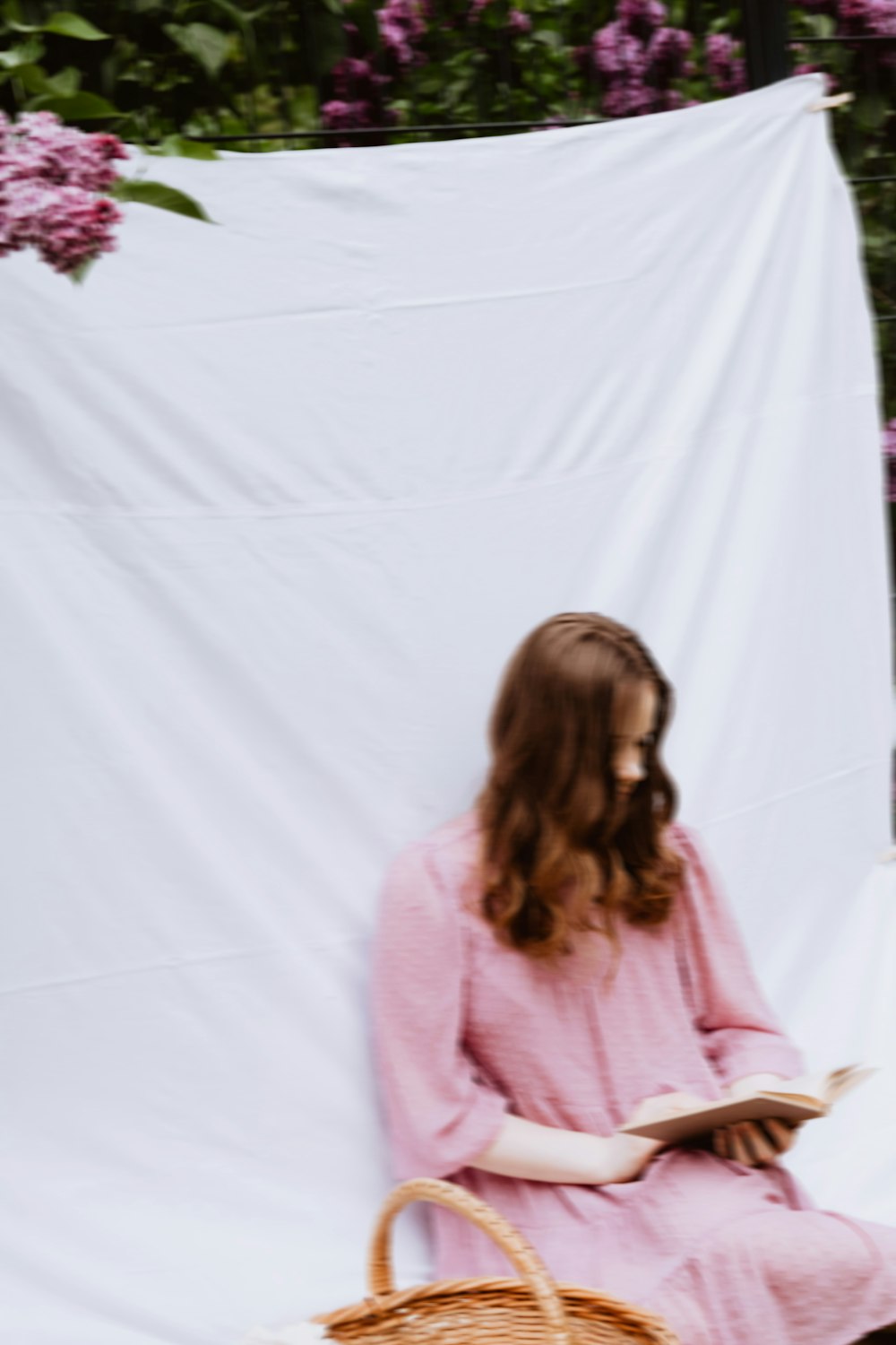 a woman in a pink dress reading a book