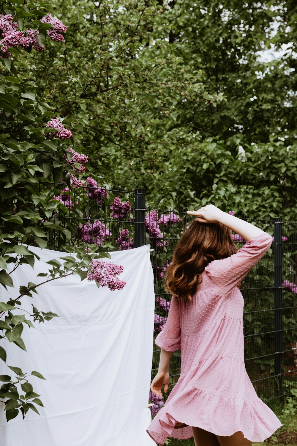 a woman in a pink dress and a white sheet