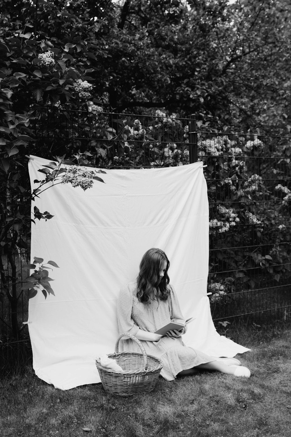 a black and white photo of a woman sitting on the ground