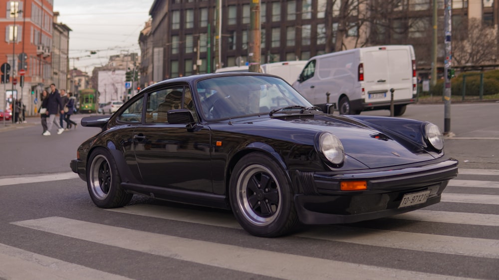 a black porsche parked on the side of the road