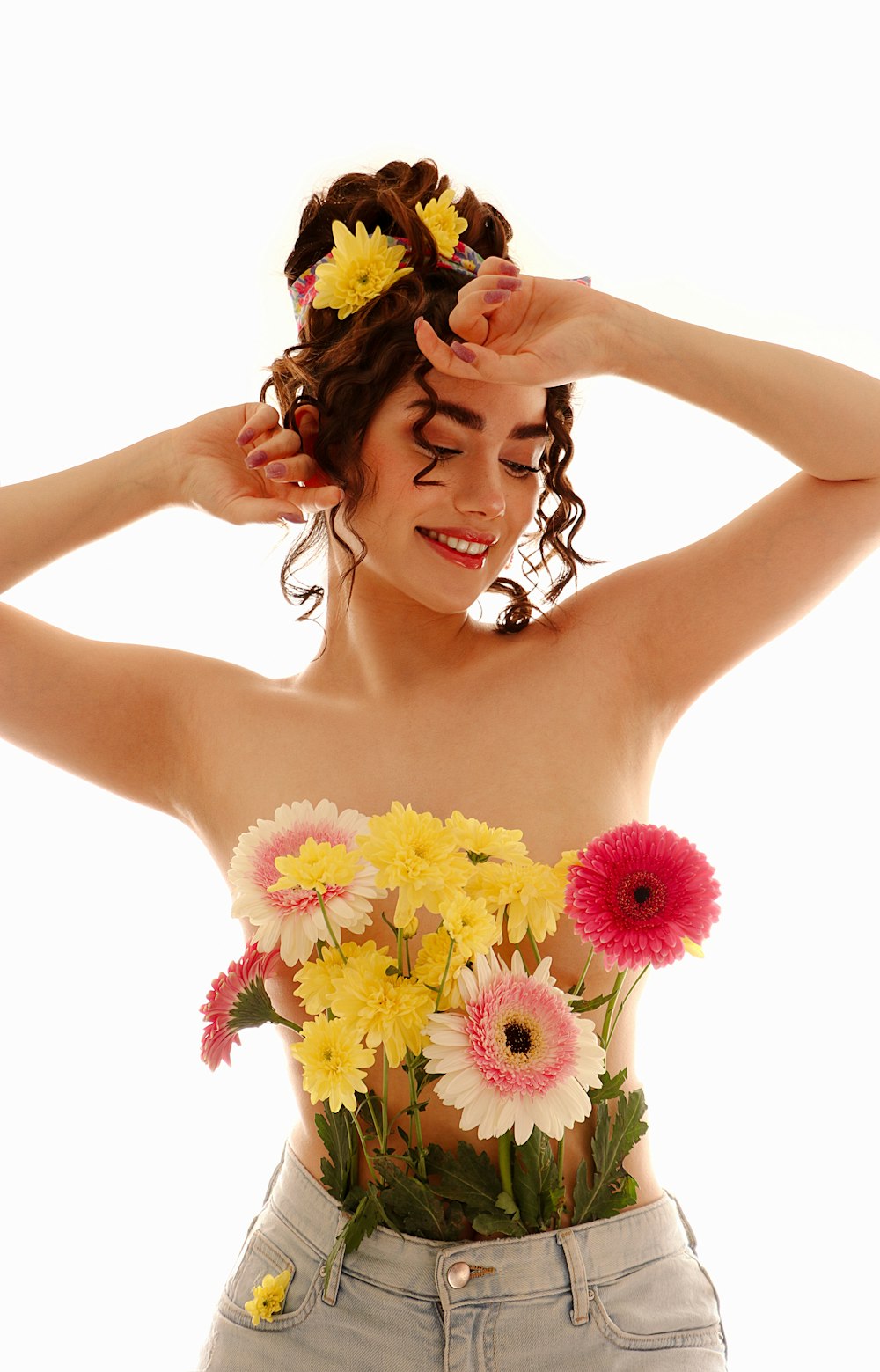 a woman with flowers in her hair holding her hands behind her head