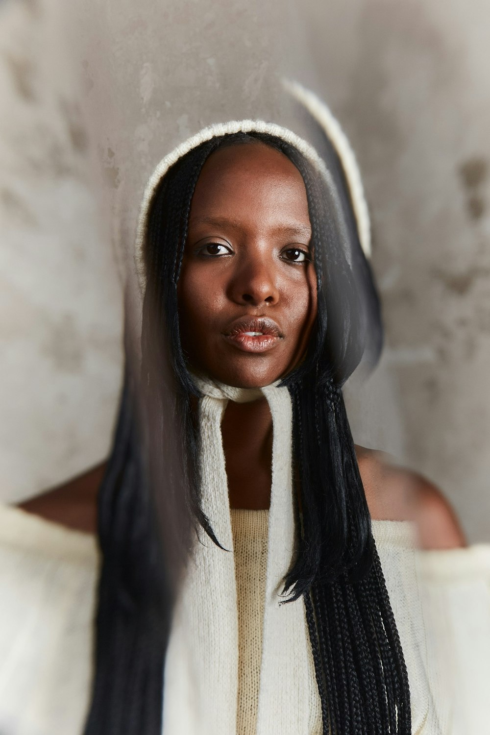 a woman with long black hair wearing a white sweater