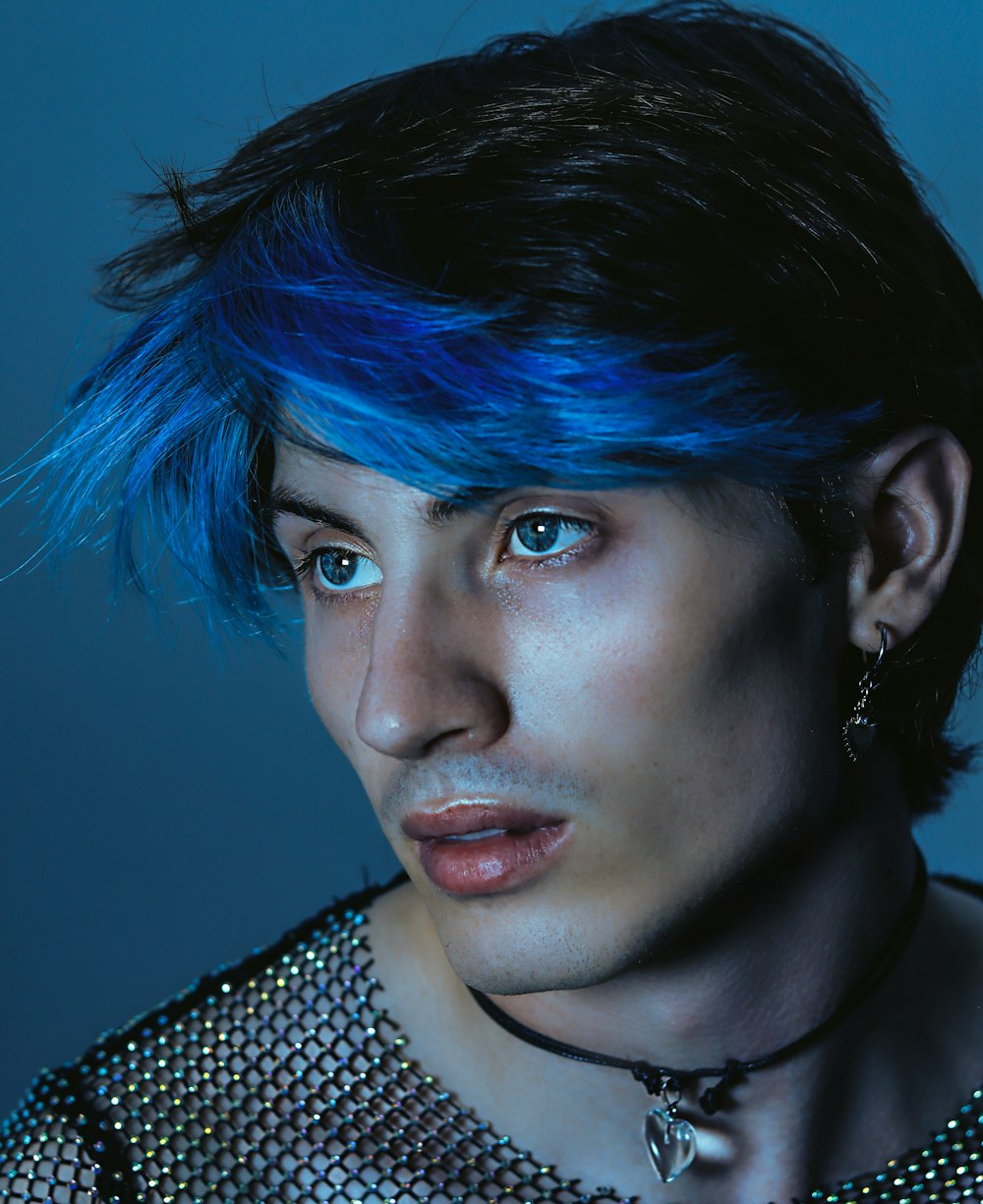 a young man with blue hair and piercings