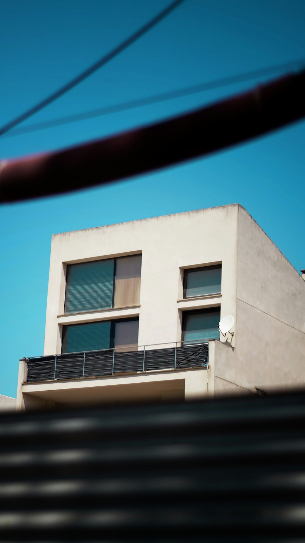 a white building with a balcony and a sky background