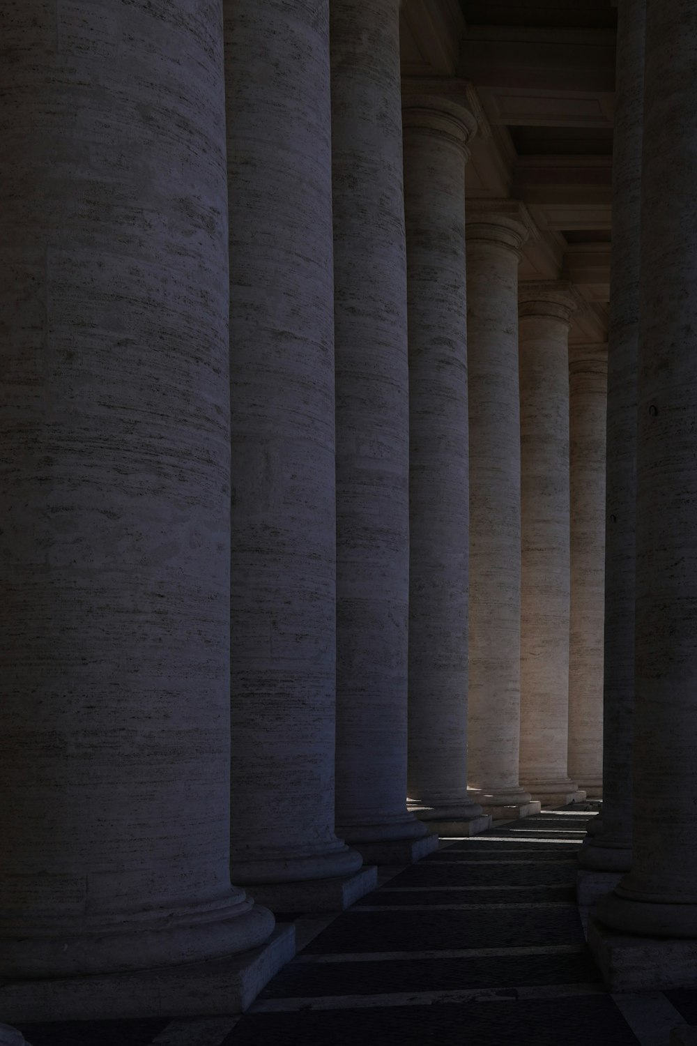 a row of columns with a clock on the top of one of them