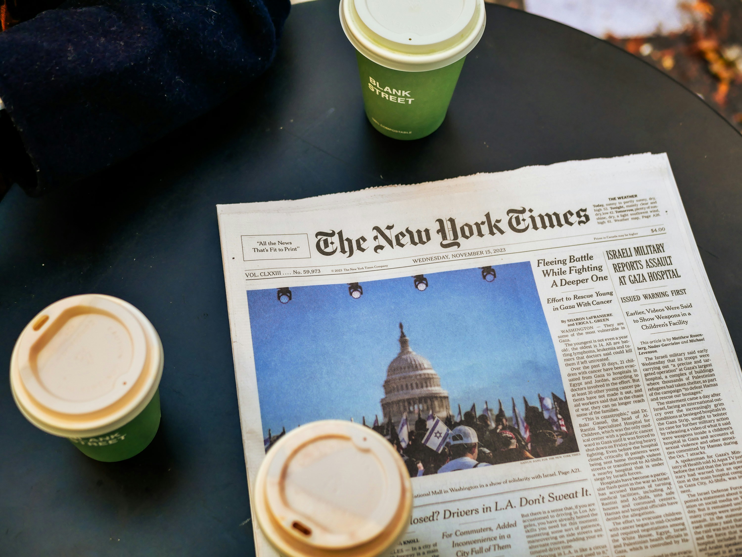 a newspaper sitting on top of a table next to two cups of coffee