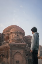 a man standing in front of a large building