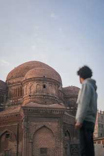 a man standing in front of a large building