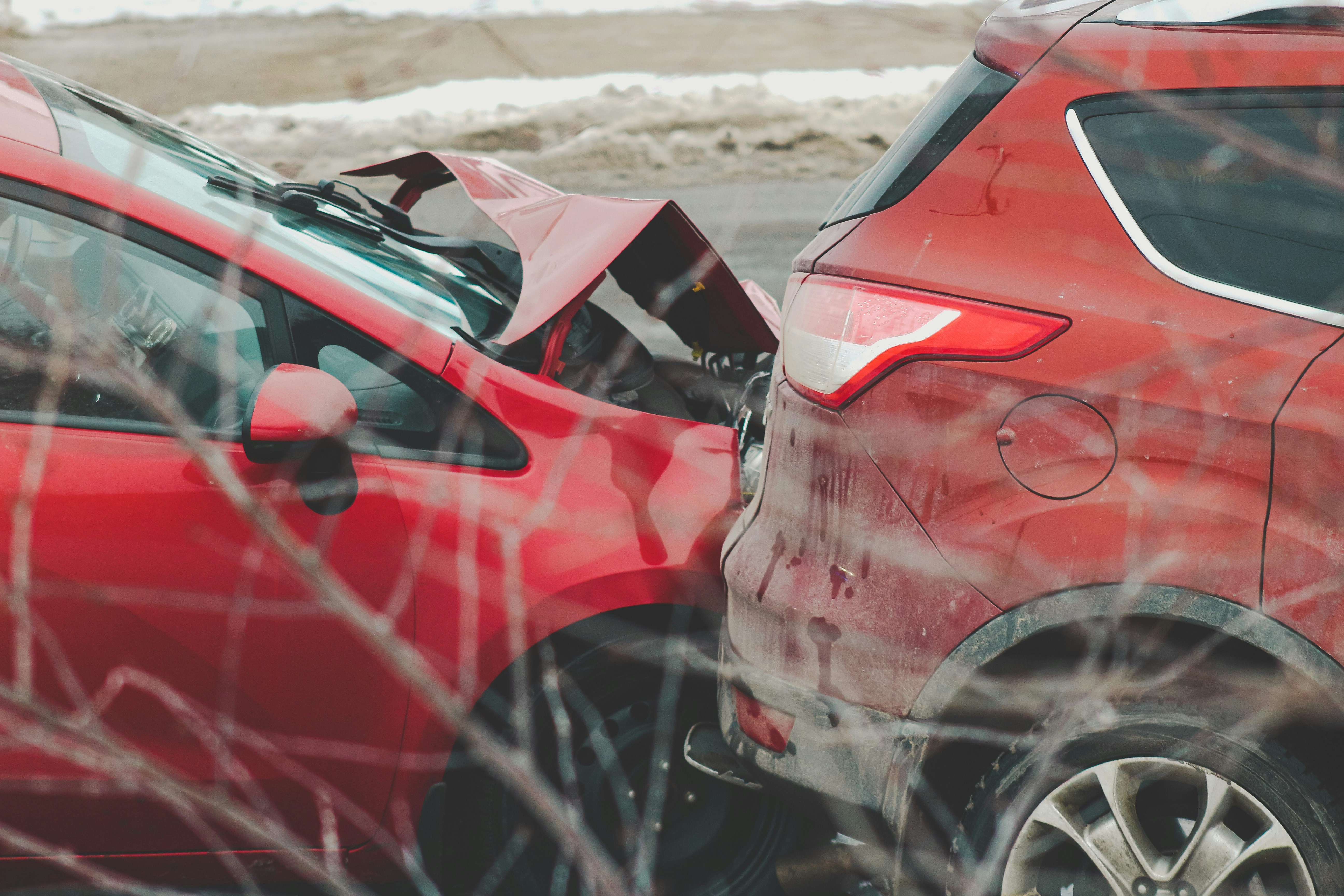 a couple of red cars parked next to each other