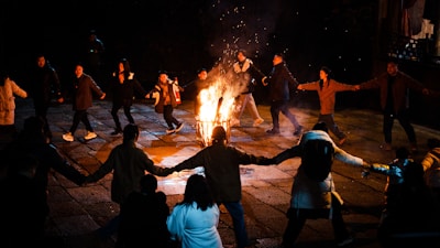 a group of people standing around a fire pit
