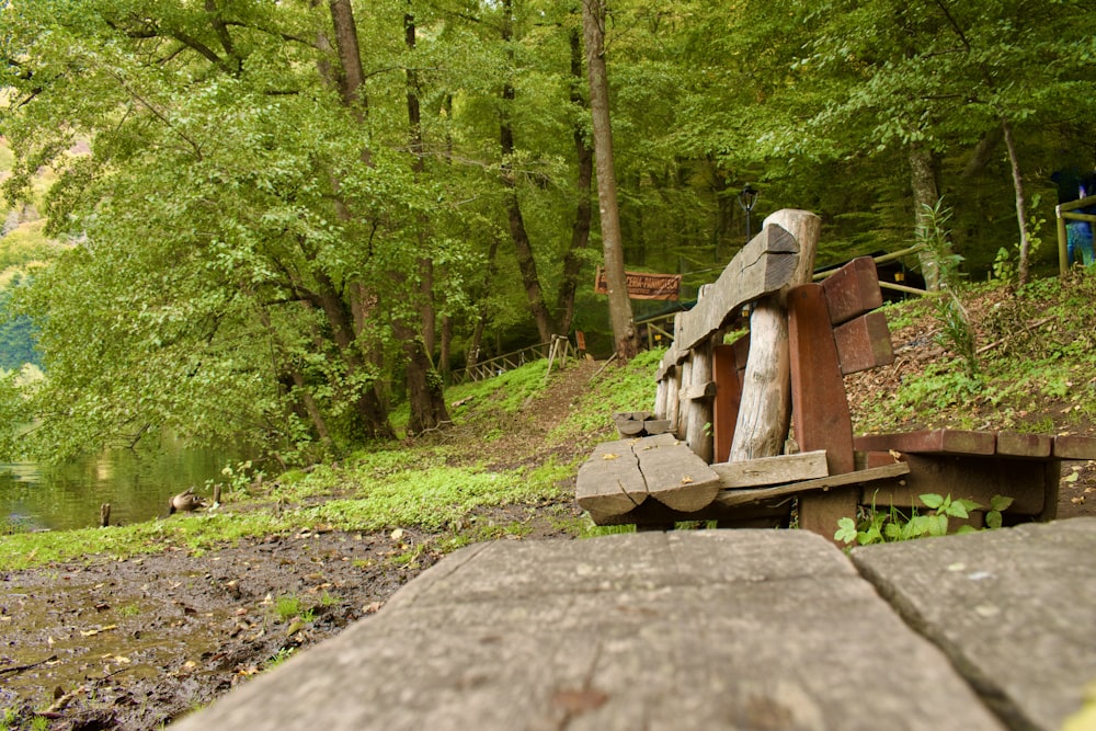 a wooden bench sitting on the side of a river