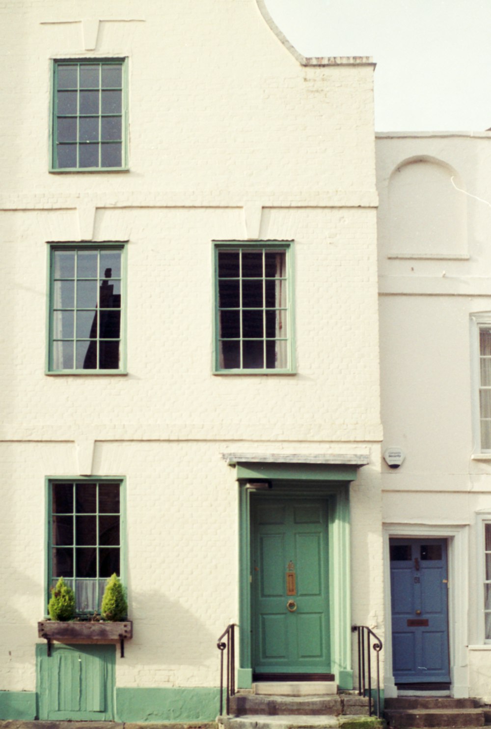 a white house with a green door and windows