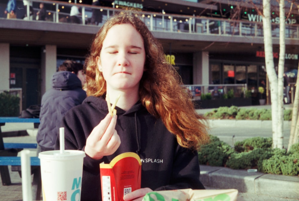 a woman sitting at a table eating food