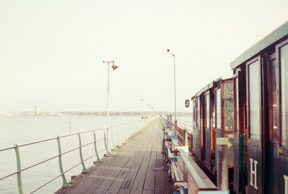 a long wooden pier next to a body of water