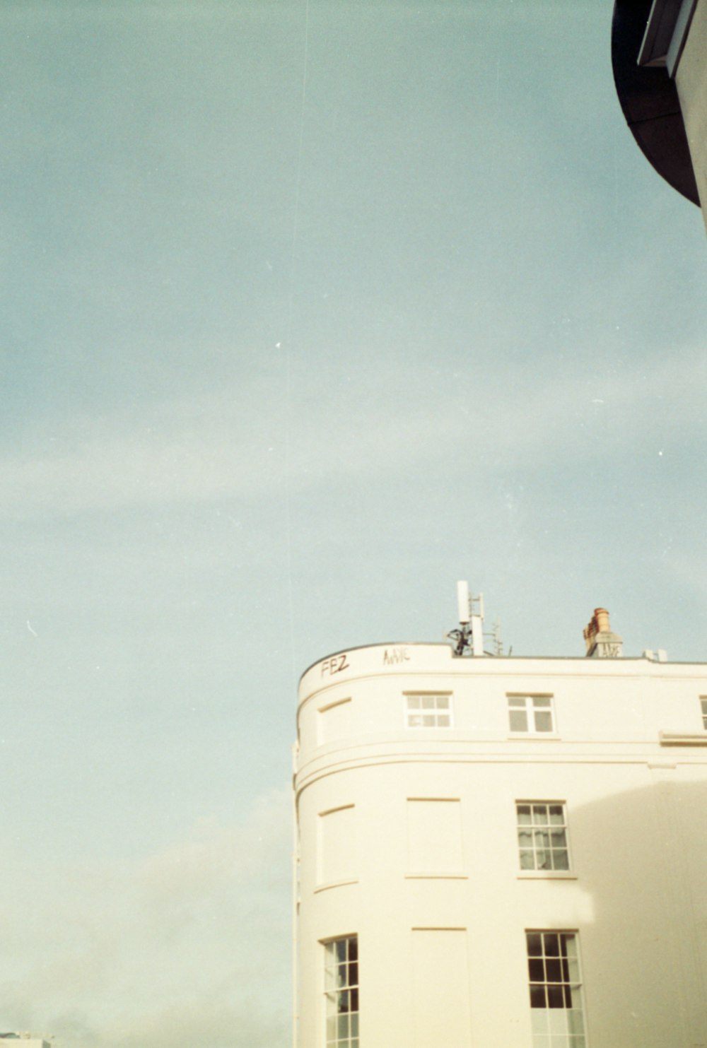 a tall white building sitting next to a traffic light