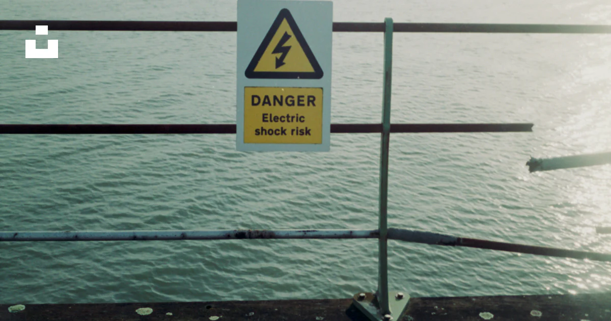 Danger Railing Signage A danger sign on a railing overlooking a body of water photo – Free ...