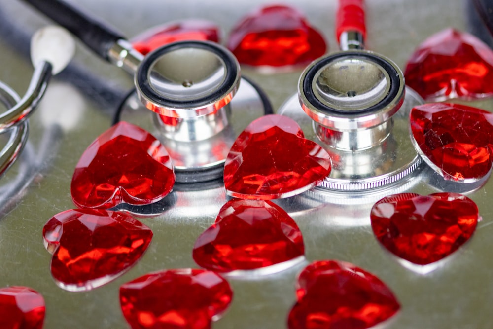 un estetoscopio y unos corazones rojos sobre una mesa