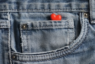 a red heart in the pocket of a pair of jeans