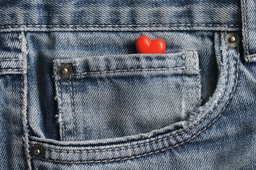 a red heart in the pocket of a pair of jeans