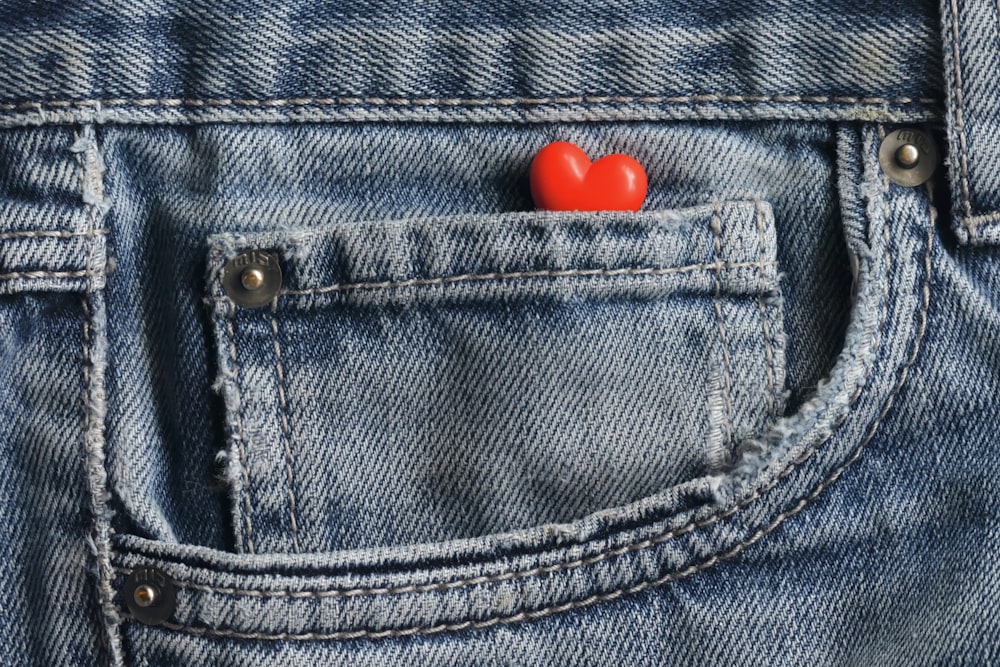 a red heart in the pocket of a pair of jeans