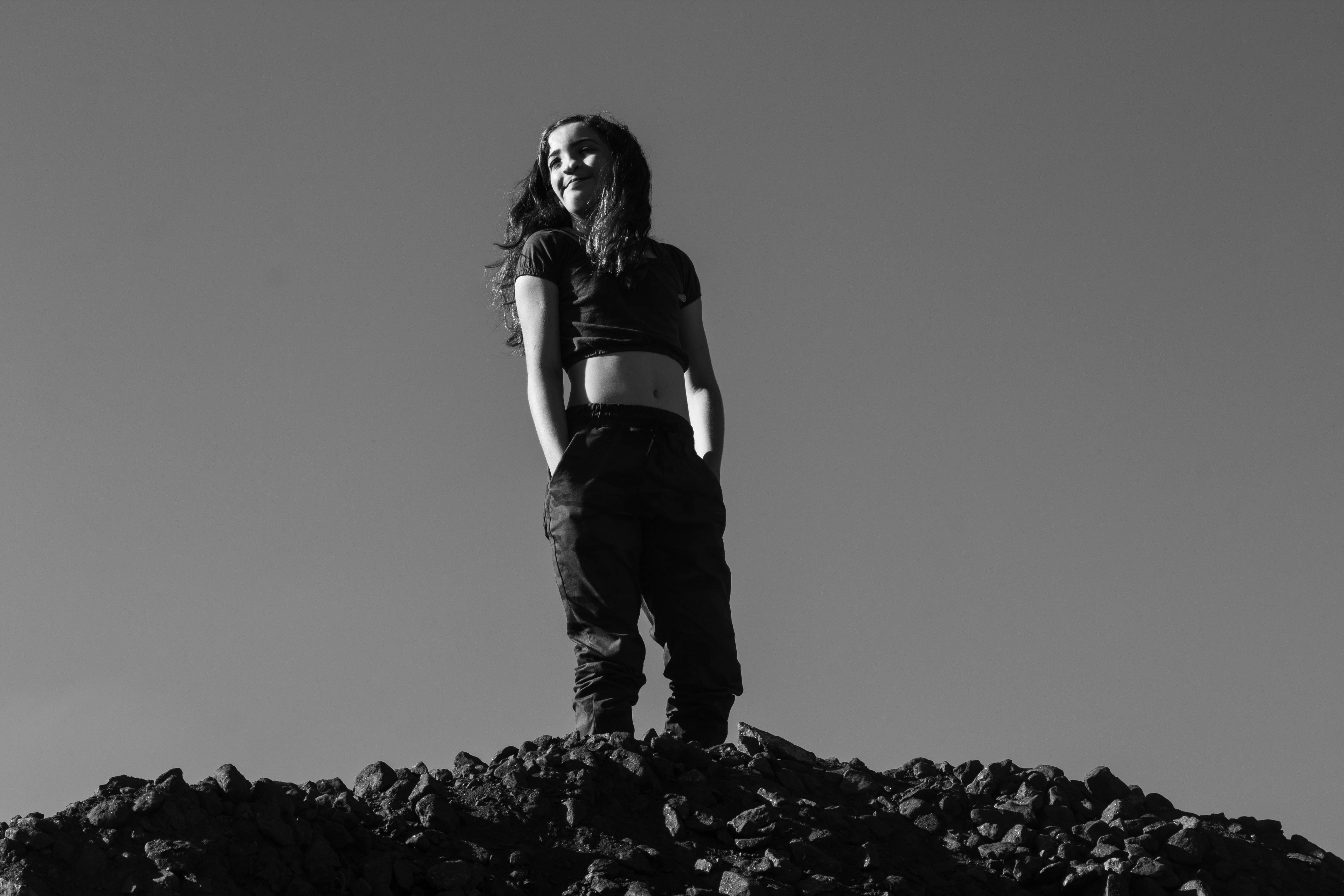 a woman standing on top of a pile of rocks